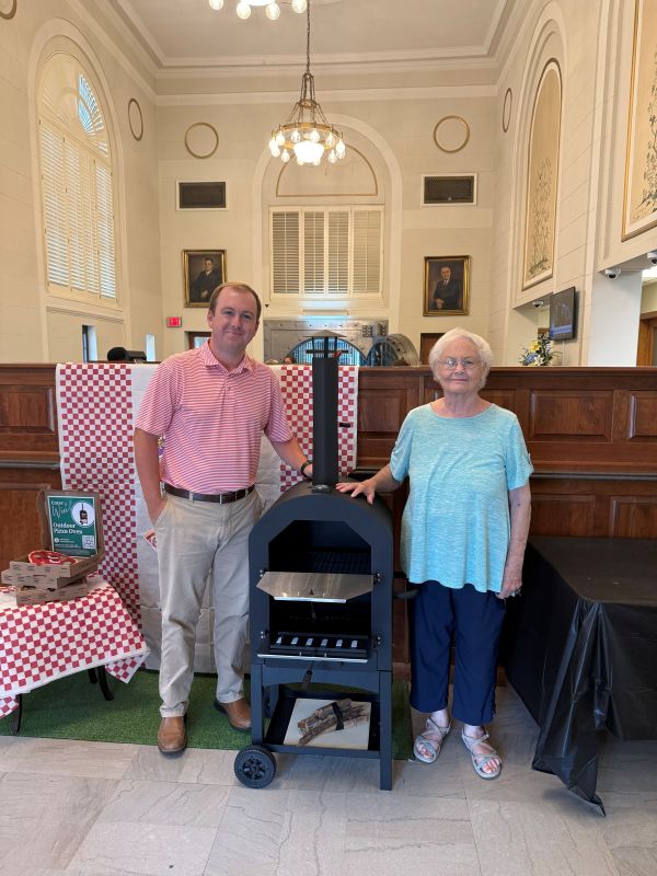 Wesley presents Betty, the Mullins Main sweepstakes winner, with her new pizza oven.