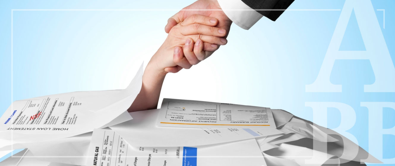 Hand reaching for help under pile of bills