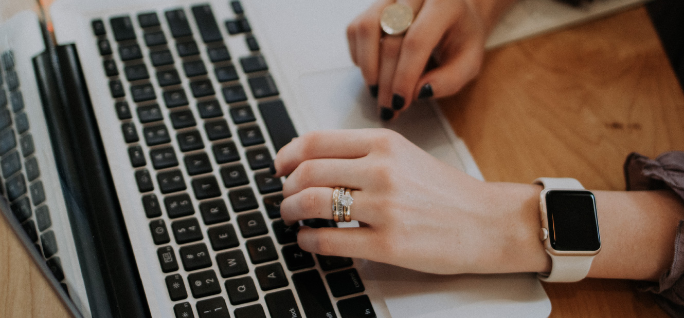 Close up of a person's hands while typing on their laptop