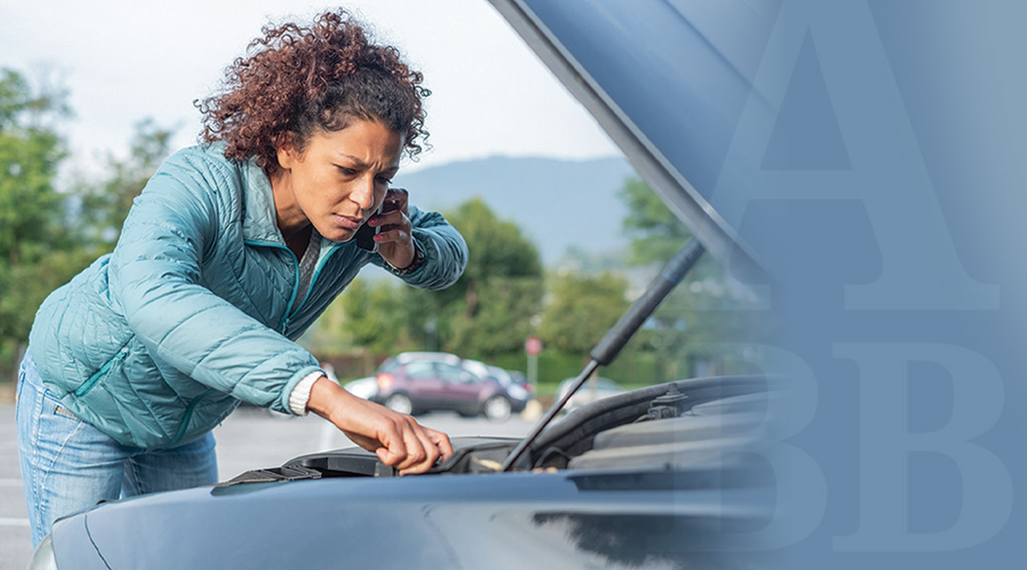 Woman checking under car hood