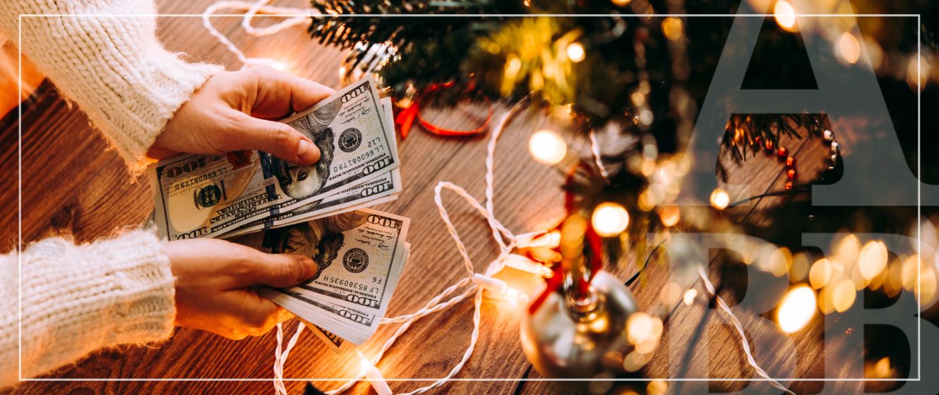 Hands counting cash while leaning over the holiday decorations