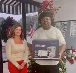 Jonathan holding an Espresso Machine presented by Latta employee Courtney
